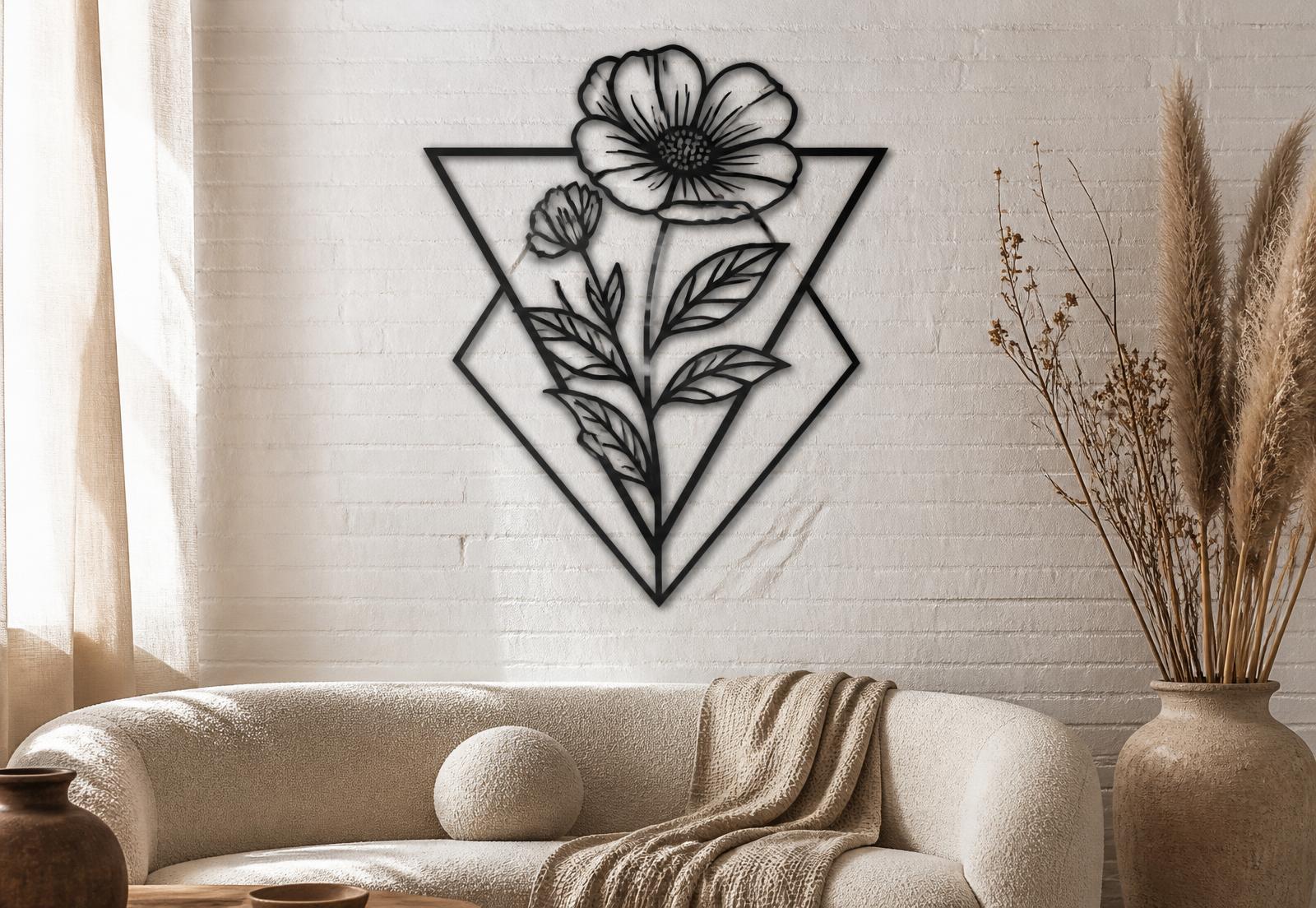 Black laser-cut metal botanical artwork within geometric outlines, mounted on a white brick wall above a cream sofa